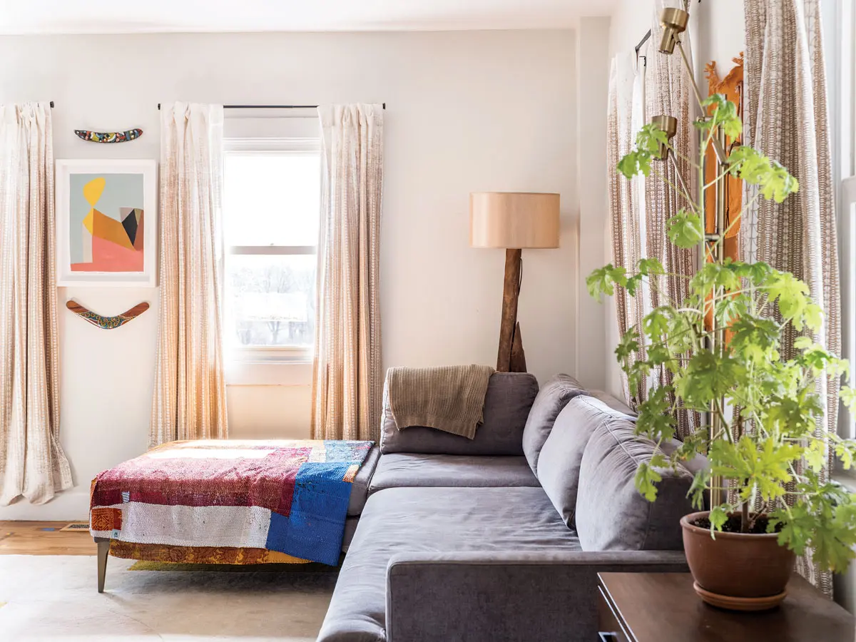In the living room, a Kristin Texeira painting hangs above a West Elm sectional.