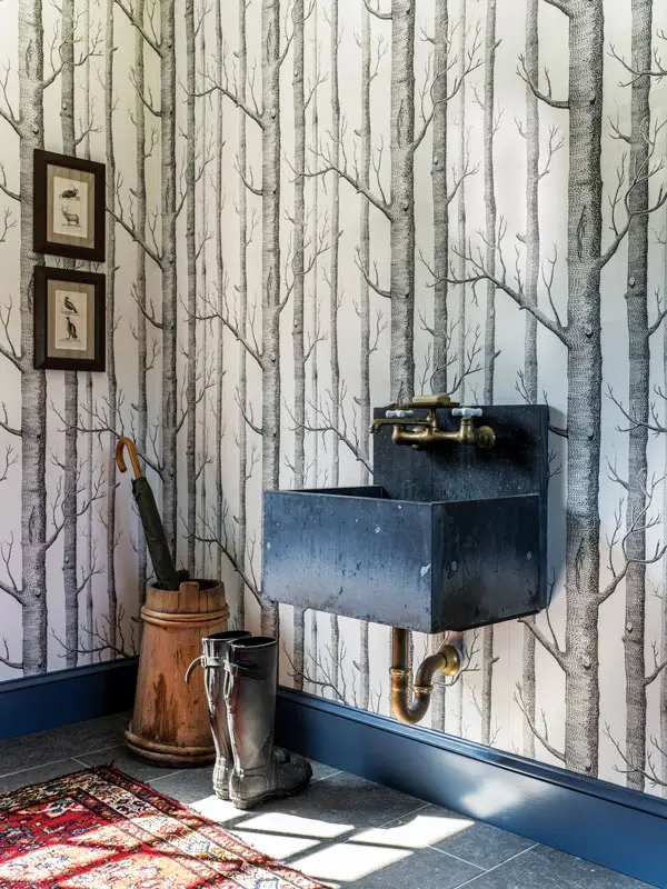 A Cole & Son wallpaper forest envelops Rosie Williams and Matt Marston’s Cumberland mudroom, which also features trim in Benjamin Moore’s Van Deusen Blue, a slate sink from Portland Architectural Salvage, and limestone tile sourced, along with bath tile, from Scarborough’s Classic Flooring.