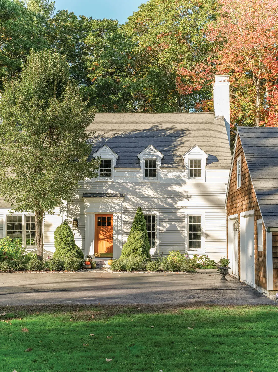 A new stained-wood door pops against clapboards in Benjamin Moore’s Apparition.
