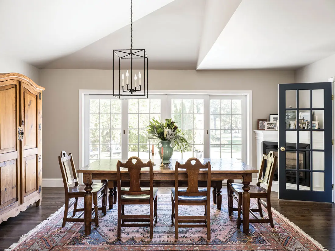 In the dining room, an antique kilim rug grounds a walnut table and bench from Craigslist and antique law-library chairs from a Portland firm.