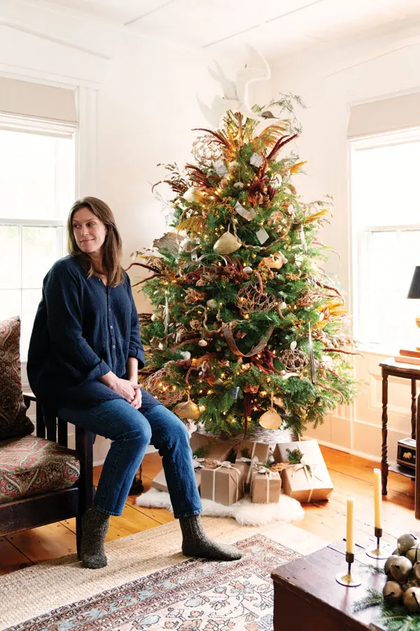 home-décor designer Michelle Provencal in front of the Christmas tree in the living room of her 1850 Waldoboro Greek Revival