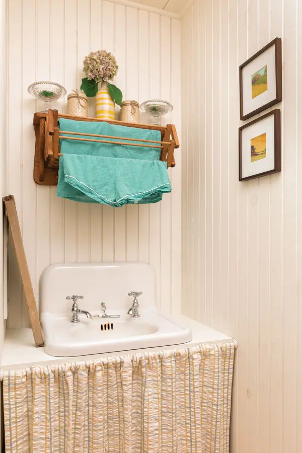 zajk-3 In the laundry room, a vintage sink wears a seersucker skirt.
