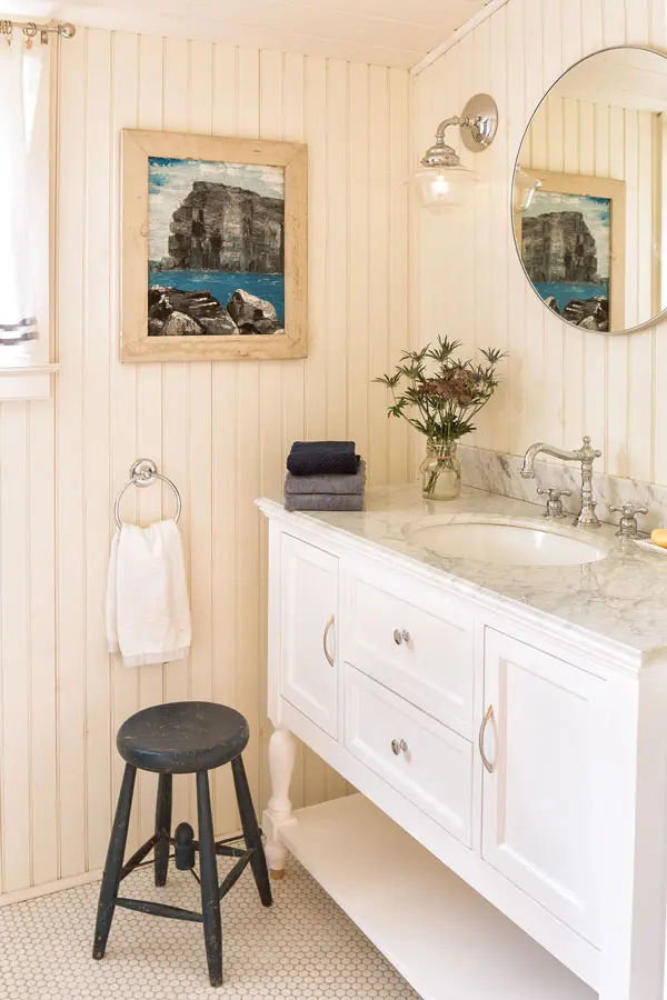zajk-8 In the upstairs bath, a Wayfair Carrara-marble-topped vanity picks up the variegated grays in an antique painting.