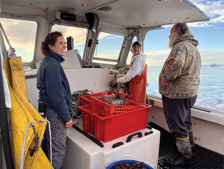 Island Institute Fellow Alumnus Jes Stevenson on a lobsterboat with two lobstermen