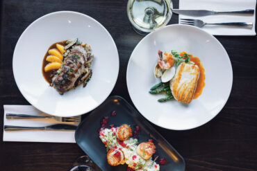 Alstation Station's seared Maine dayboat scallops with cranberry risotto and cranberry-orange relish; duck breast à l’orange with shiitake mushrooms and quinoa pilaf; pan-roasted Maine halibut in a bouillabaisse sauce.