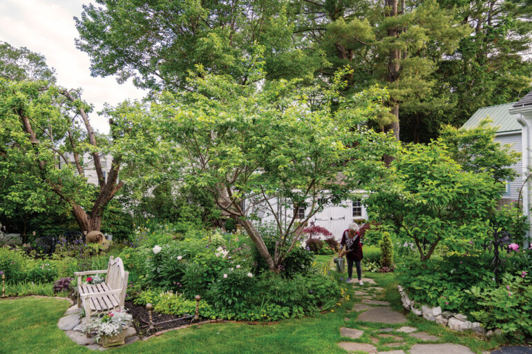 Robin Robinson watering the plants in her Brunswick garden