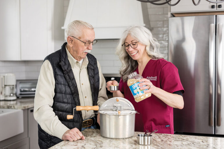 Andwell Health Partners aid helping an elderly gentleman make popcorn