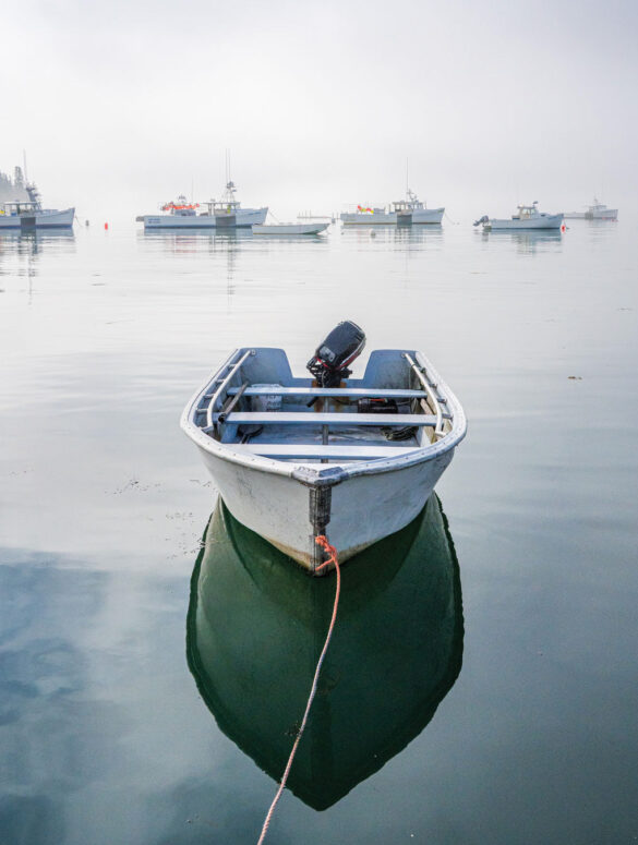a small boat with a clear reflection on the water