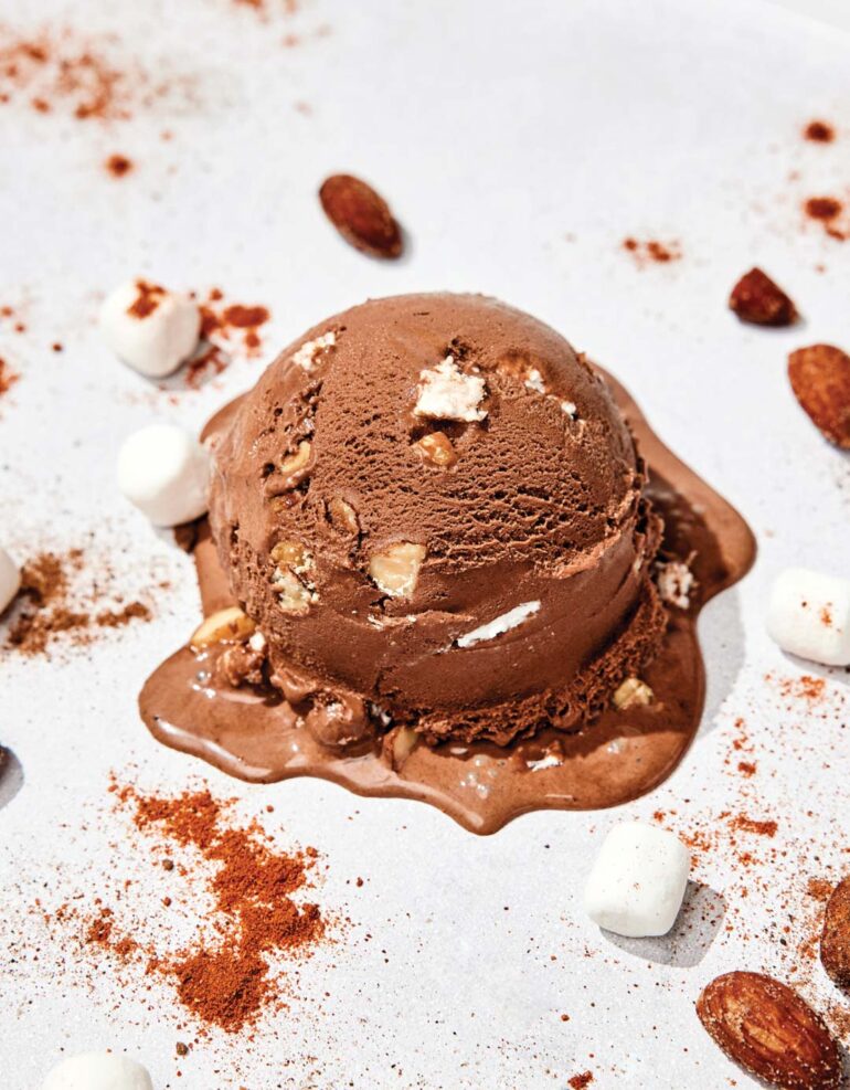 Scoop of Spicy Rocky Road ice cream surrounded with nuts and marshmallows