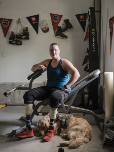Christy Gardner takes a break from training in her home gym with Doug, a service dog, to sit for a portrait