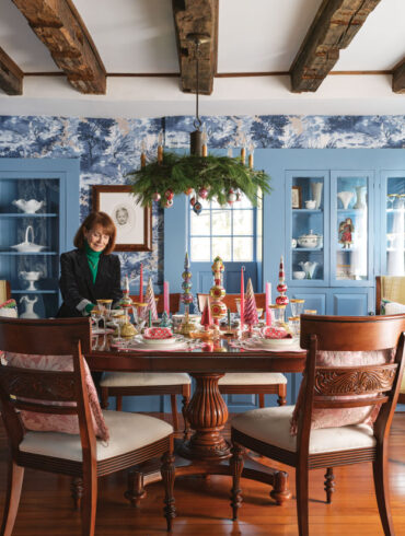 Judy Minaudo standing in the dining room of Kennebunk's James Hubbard House, which is decked out in holiday decor