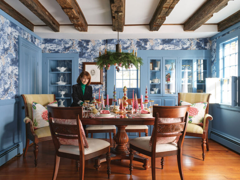 Judy Minaudo standing in the dining room of Kennebunk's James Hubbard House, which is decked out in holiday decor