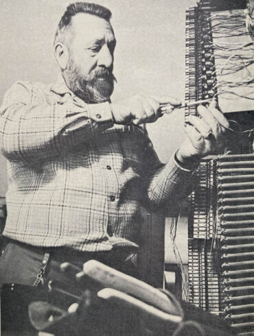 Elden Hathaway connects a circuit on a hand-crank telephone