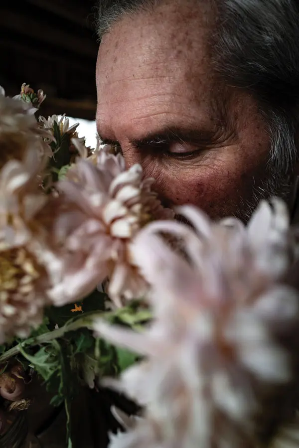 writer Joseph Monninger smelling a bouquet of flowers