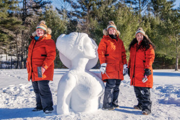 The Chickadees, Maine's all female snow-sculpting team with their practice snow-sculpture of Artemis in Waterville Maine