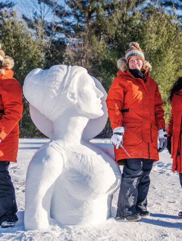 The Chickadees, Maine's all female snow-sculpting team with their practice snow-sculpture of Artemis in Waterville Maine