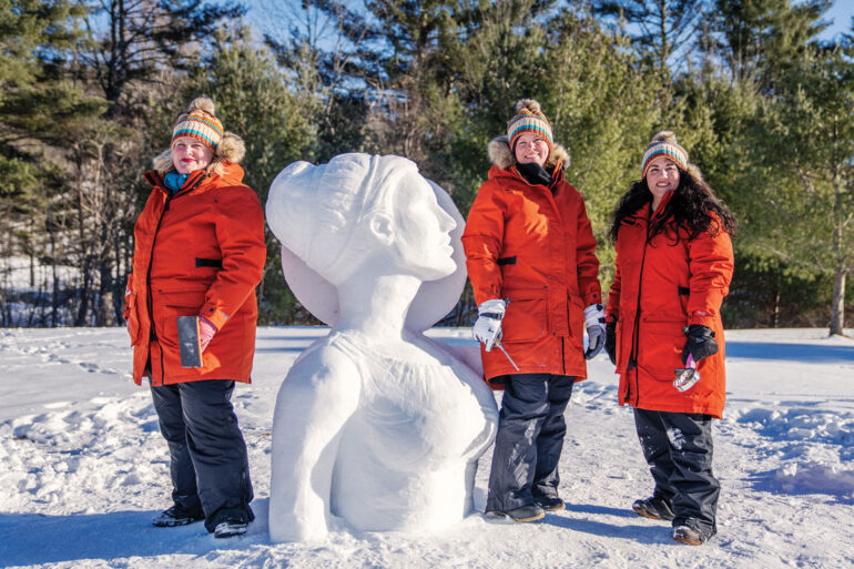 The Chickadees, Maine's all female snow-sculpting team with their practice snow-sculpture of Artemis in Waterville Maine