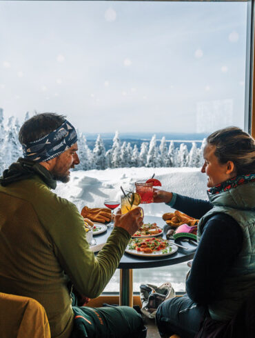 a couple enjoying a meal and the view at The Nest on Saddleback Mountain