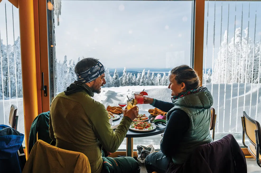 a couple enjoying a meal and the view at The Nest on Saddleback Mountain
