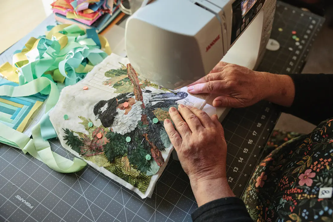 Judy Gates sewing together one of her fabric collages