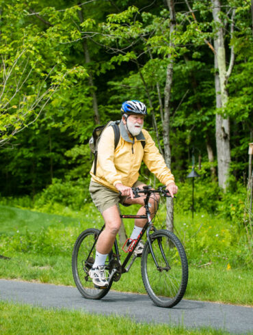 a retiree riding a bike on a paved path