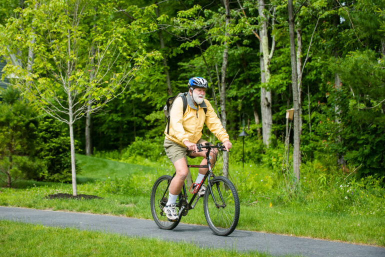 a retiree riding a bike on a paved path