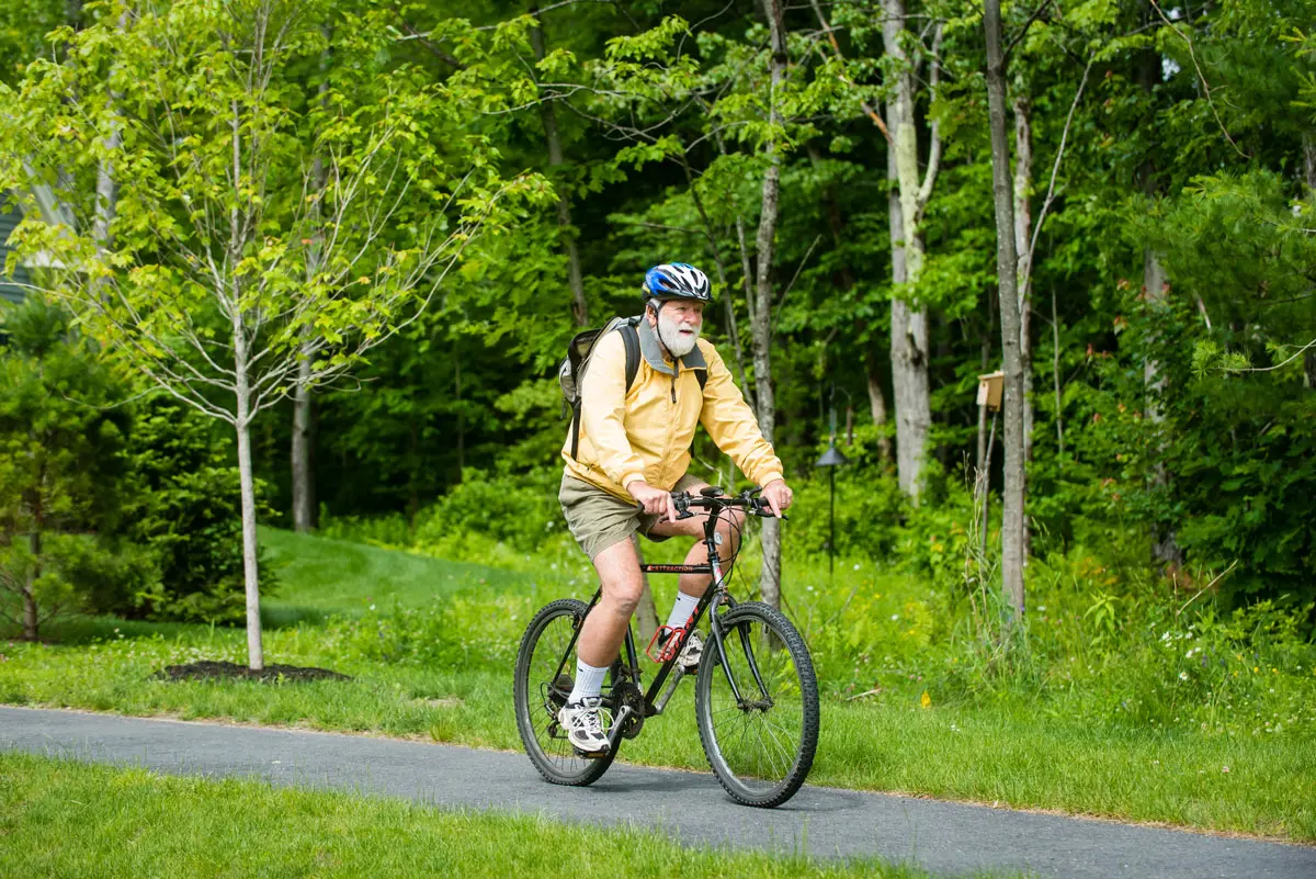 a retiree riding a bike on a paved path