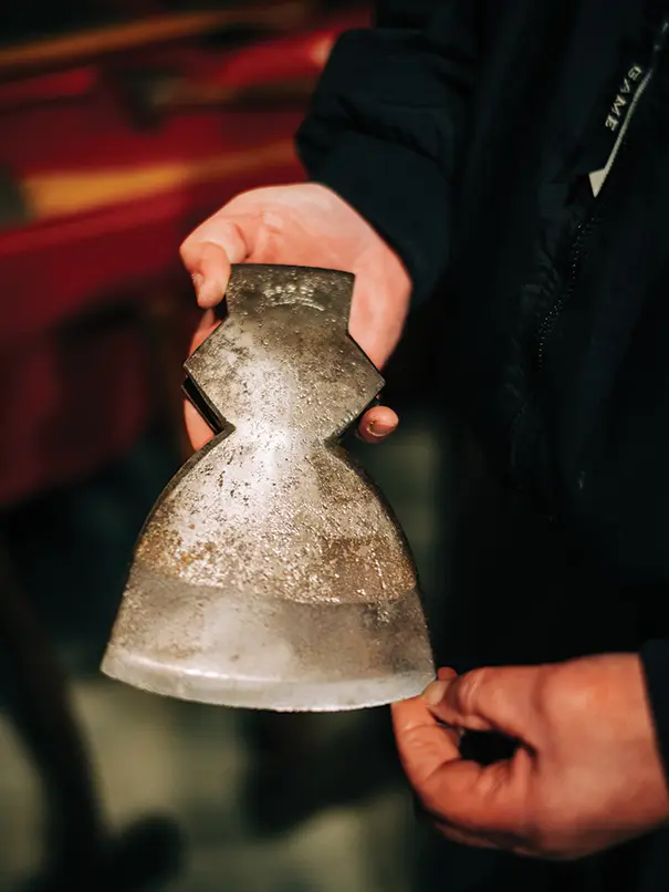 maker showing off the edge of a handmade axe head