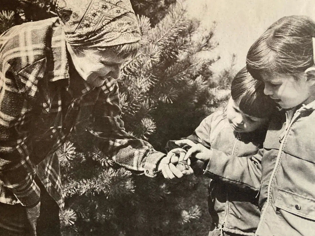 Jerry Elwell shows two children the injured bird in her hand