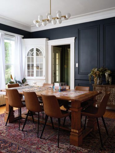 Behr’s Midnight Blue on the walls and a Sofary globe chandelier provide modern counterpoints in the otherwise historic looking dining room