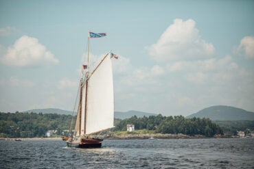 Schooner Stephen Taber sails towards Curtis Island Light, at the entrance of Camden Harbor.