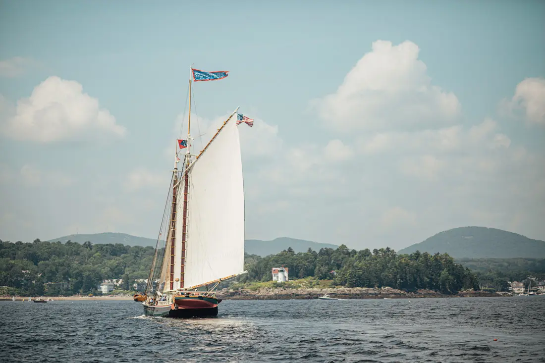 Schooner Stephen Taber sails towards Curtis Island Light, at the entrance of Camden Harbor.