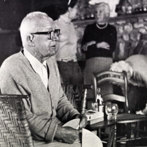 Bucky Fuller (R. Buckminster Fuller) with a cardboard dome model.