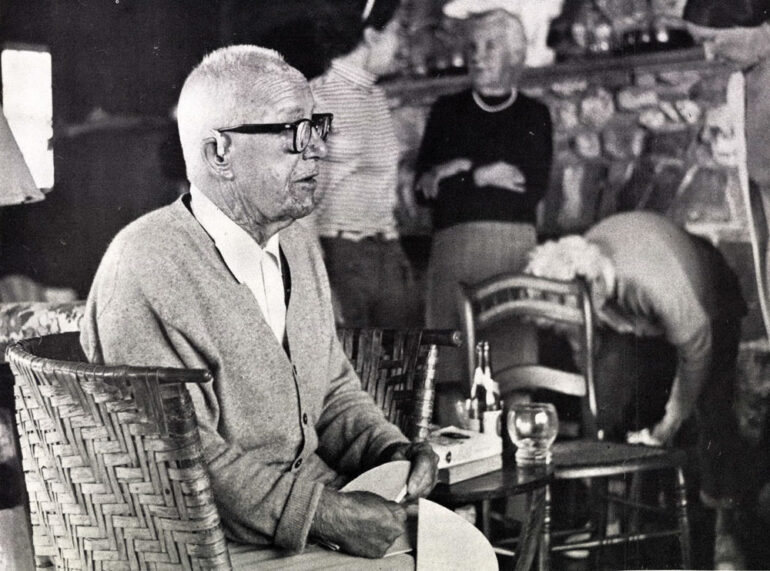 Bucky Fuller (R. Buckminster Fuller) with a cardboard dome model.