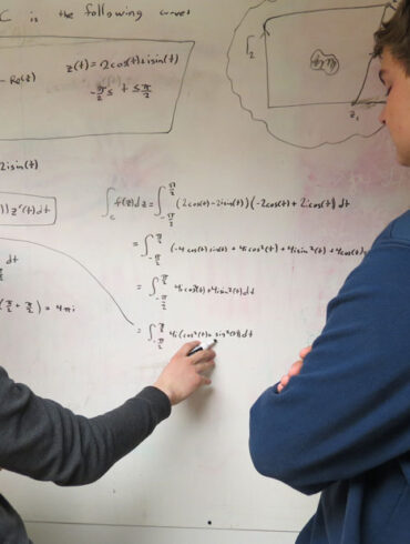 Maine School of Science and Mathematics students at the whiteboard discussing physics