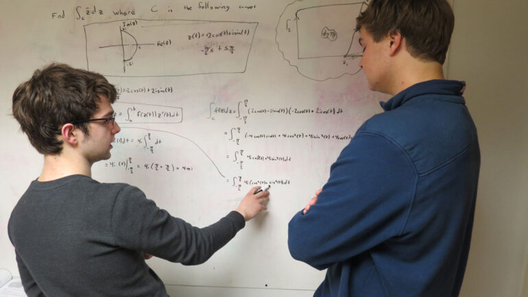 Maine School of Science and Mathematics students at the whiteboard discussing physics