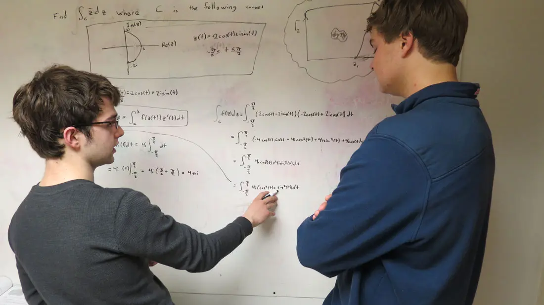 Maine School of Science and Mathematics students at the whiteboard discussing physics