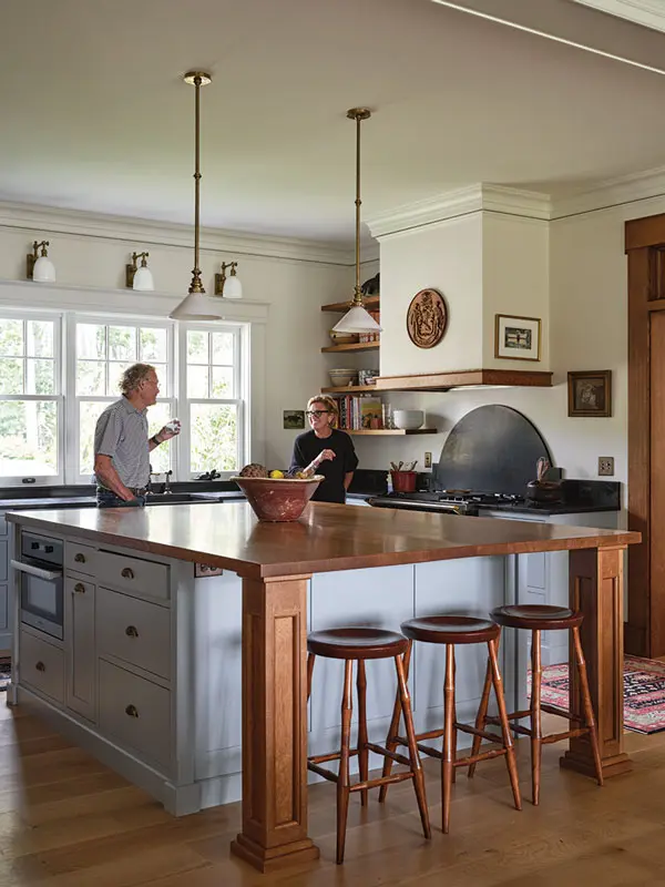 Ford and Karen Reiche in their kitchen, which features leaded-glass transoms from New Jersey’s former Elmer Runyan House, and an oak counter top