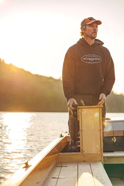 Ellery Brown helming the electric Anchovy, built at Hylan & Brown with a long, low hull that makes it efficient and suits it to cruising inland waters.