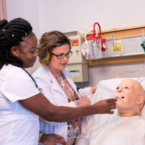 a University of Maine at Fort Kent nursing student and instructor practice on a medical dummy