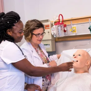 a University of Maine at Fort Kent nursing student and instructor practice on a medical dummy