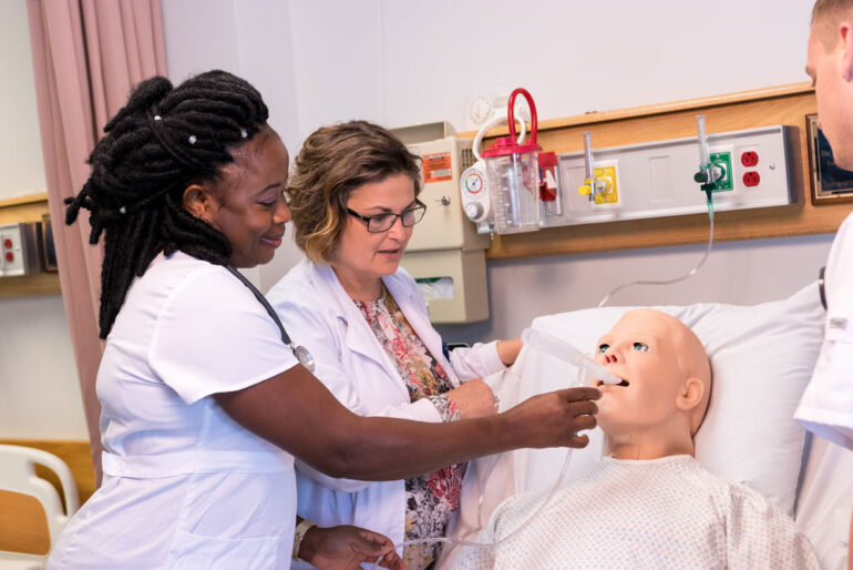 a University of Maine at Fort Kent nursing student and instructor practice on a medical dummy
