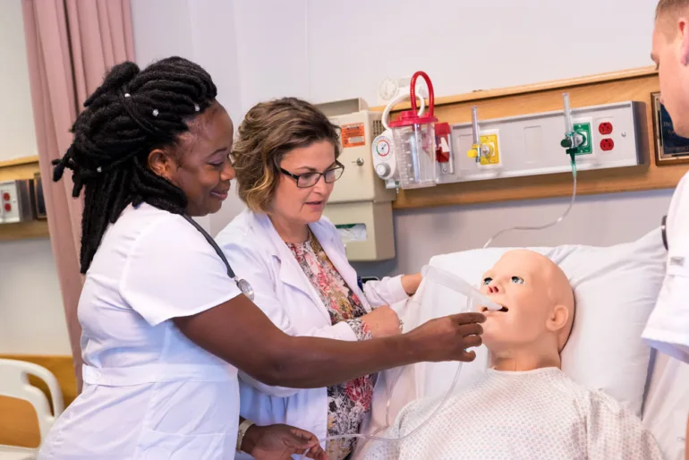 a University of Maine at Fort Kent nursing student and instructor practice on a medical dummy