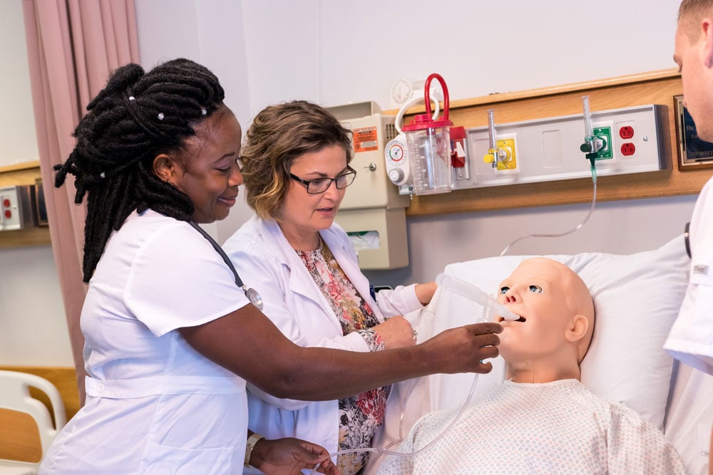 a University of Maine at Fort Kent nursing student and instructor practice on a medical dummy
